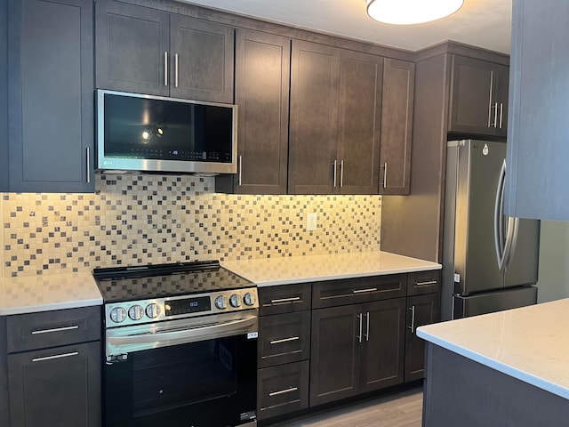 1848 Milden Rd, Columbus, OH 43221 - kitchen with stainless steel appliances, decorative backsplash, dark brown cabinets, and light wood-style floors