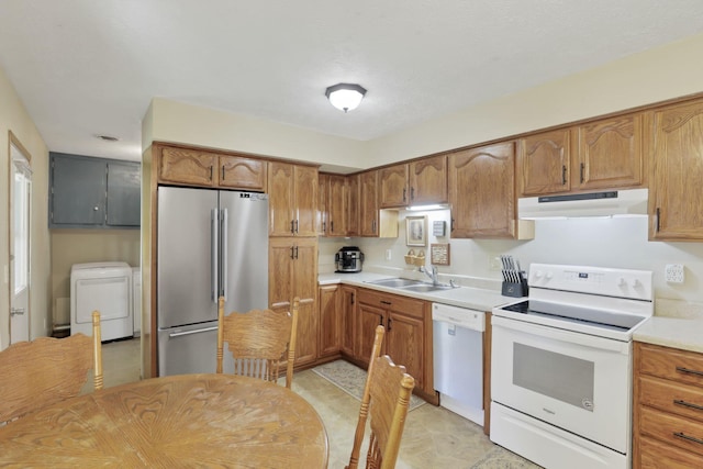 110 Creekview Dr, Baltimore, OH 43105 - kitchen with white appliances, under cabinet range hood, separate washer and dryer, light countertops, and brown cabinetry