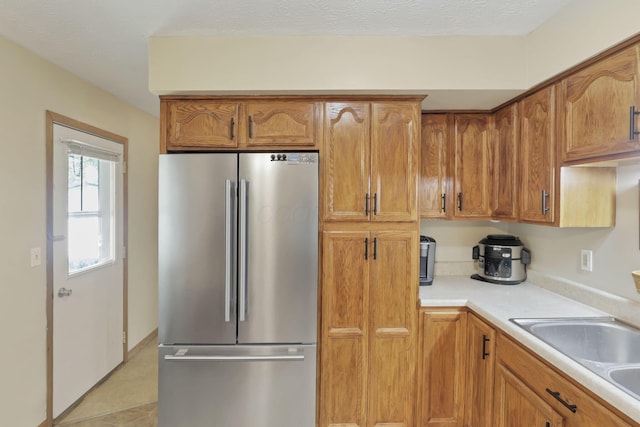 110 Creekview Dr, Baltimore, OH 43105 - kitchen featuring freestanding refrigerator, light countertops, and brown cabinetry