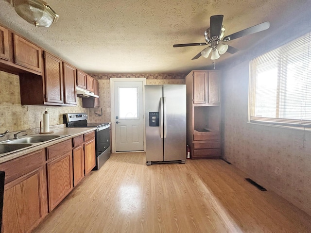 1444 Chesterton Sq N, Columbus, OH 43229 - kitchen featuring appliances with stainless steel finishes, light wood-style floors, under cabinet range hood, a ceiling fan, and brown cabinetry