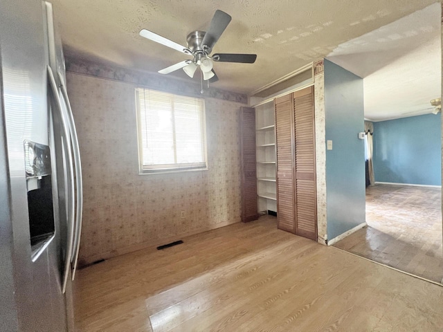 1444 Chesterton Sq N, Columbus, OH 43229 - unfurnished bedroom featuring stainless steel refrigerator with ice dispenser, wood finished floors, a closet, ceiling fan, and a textured ceiling
