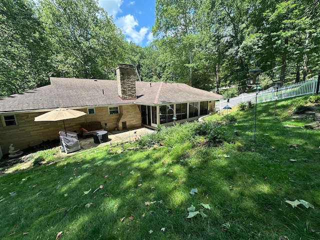 1080 Sycamore Dr, Lancaster, OH 43130 - back of property featuring a sunroom, a patio, a chimney, and roof with shingles