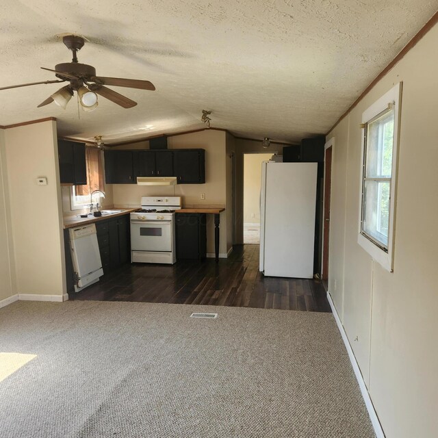 3137 Westerville Rd Unit 91, Columbus, OH 43224 - kitchen featuring white appliances, dark colored carpet, a textured ceiling, lofted ceiling, and dark cabinets