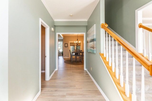 419 Wooten Ct S, Powell, OH 43065 - hallway featuring wood finished floors, a chandelier, ornamental molding, and stairs