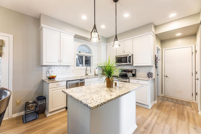 419 Wooten Ct S, Powell, OH 43065 - kitchen with stainless steel appliances, light wood-style floors, white cabinetry, tasteful backsplash, and recessed lighting