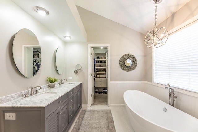 419 Wooten Ct S, Powell, OH 43065 - full bath with double vanity, a freestanding bath, a walk in closet, wainscoting, and a chandelier