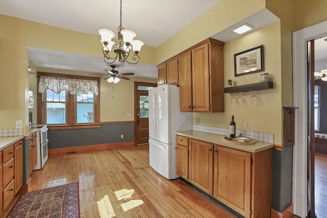 206 E Fair Ave, Lancaster, OH 43130 - kitchen featuring freestanding refrigerator, light countertops, light wood finished floors, a chandelier, and brown cabinets