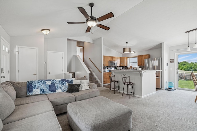 2587 Weeping Willow Ct, Columbus, OH 43207 - living area with light carpet, lofted ceiling, stairs, and a ceiling fan