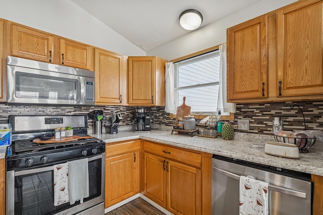 2587 Weeping Willow Ct, Columbus, OH 43207 - kitchen featuring appliances with stainless steel finishes, lofted ceiling, decorative backsplash, and light stone counters