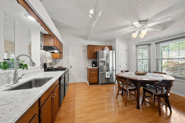 3625 Peany Ln, Canal Winchester, OH 43110 - kitchen with stainless steel appliances, brown cabinets, light wood-style floors, a ceiling fan, and a textured ceiling