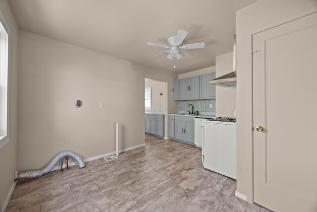 2300 Atwood Ter, Columbus, OH 43211 - kitchen with wall chimney exhaust hood, white gas range, a ceiling fan, light countertops, and tasteful backsplash