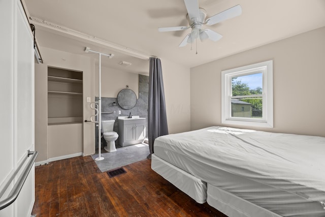 2300 Atwood Ter, Columbus, OH 43211 - bedroom featuring dark wood-type flooring, connected bathroom, ceiling fan, and a barn door