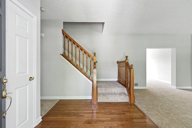 5497 Mirage Dr, Hilliard, OH 43026 - stairs featuring carpet, a textured ceiling, and wood finished floors