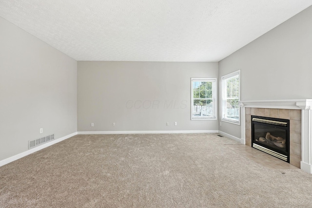 5497 Mirage Dr, Hilliard, OH 43026 - unfurnished living room featuring carpet, a tiled fireplace, and a textured ceiling