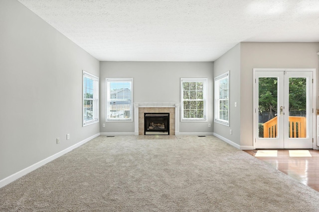 5497 Mirage Dr, Hilliard, OH 43026 - unfurnished living room with plenty of natural light, french doors, carpet flooring, a textured ceiling, and a fireplace