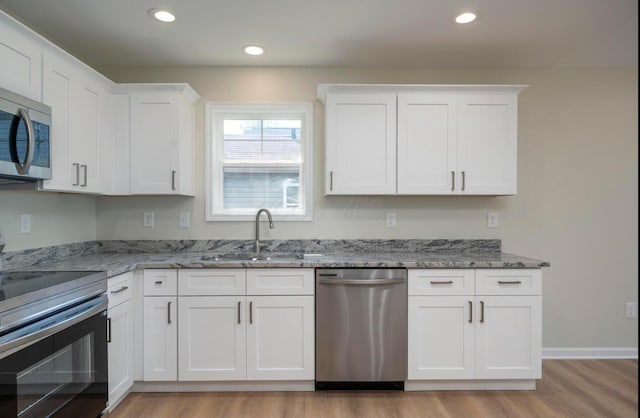 32 Maple St, Jeffersonville, OH 43128 - kitchen with stainless steel appliances, light wood-style floors, white cabinets, light stone countertops, and recessed lighting