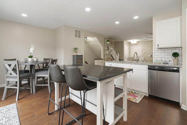 5649 Chippewa Falls St, Dublin, OH 43016 - kitchen with dishwasher, a breakfast bar area, a peninsula, white cabinets, and recessed lighting