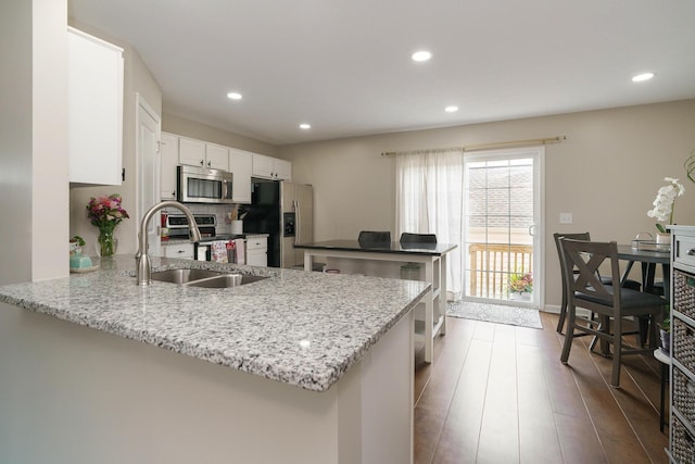5649 Chippewa Falls St, Dublin, OH 43016 - kitchen with stainless steel appliances, a peninsula, recessed lighting, dark wood-style flooring, and white cabinets