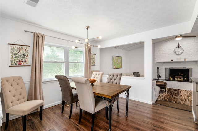 230 Barcelona Ave, Westerville, OH 43081 - dining space with dark wood-style flooring, a chandelier, a brick fireplace, and a textured ceiling