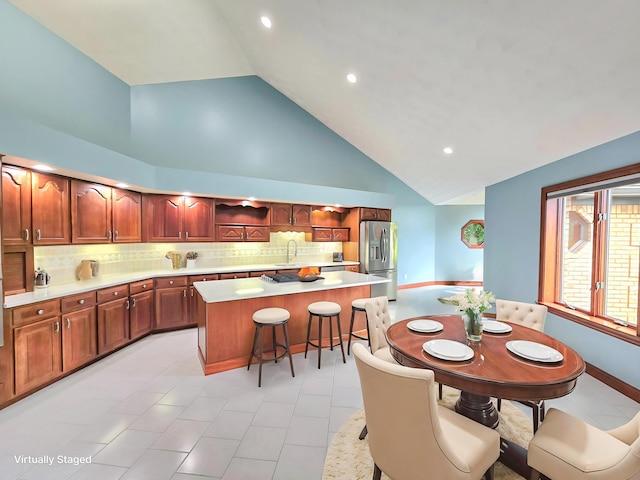 3100 Kropp Rd, Grove City, OH 43123 - kitchen featuring stainless steel refrigerator with ice dispenser, a center island, light countertops, decorative backsplash, and high vaulted ceiling