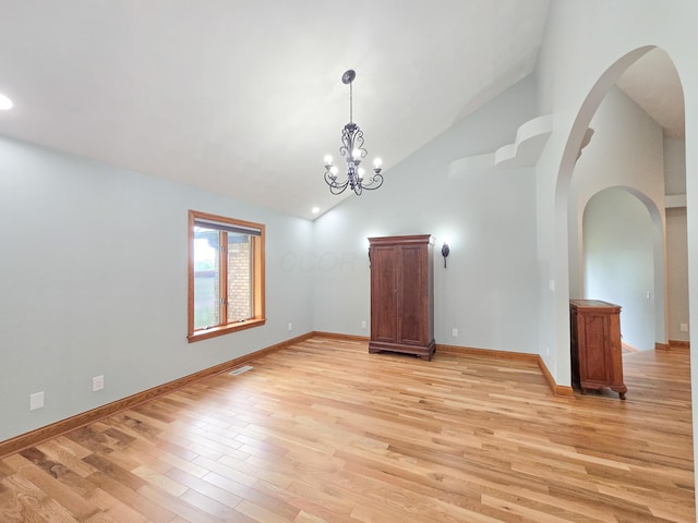 3100 Kropp Rd, Grove City, OH 43123 - spare room with light wood-style flooring, high vaulted ceiling, arched walkways, and a chandelier
