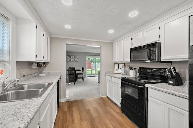 3053 E Old Duvall Ct, Lockbourne, OH 43137 - kitchen featuring black appliances, white cabinetry, light wood finished floors, a textured ceiling, and light countertops