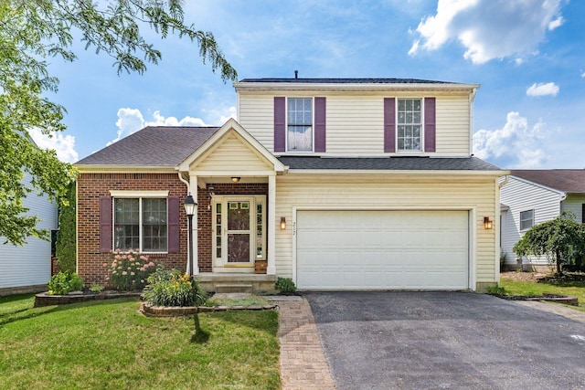 217 Knight Dream St, Delaware, OH 43015 - traditional home with a garage, asphalt driveway, a front yard, and brick siding