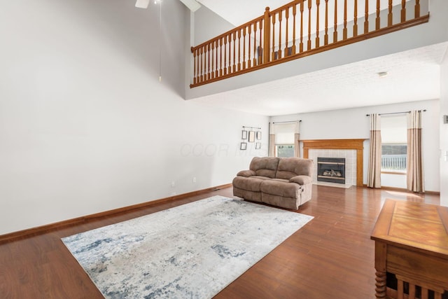 217 Knight Dream St, Delaware, OH 43015 - living area with plenty of natural light, wood finished floors, ceiling fan, a tiled fireplace, and a high ceiling