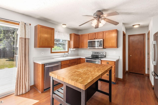 217 Knight Dream St, Delaware, OH 43015 - kitchen featuring appliances with stainless steel finishes, light wood-type flooring, light countertops, brown cabinetry, and a textured ceiling