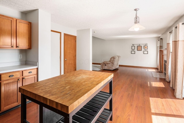 217 Knight Dream St, Delaware, OH 43015 - kitchen with dark wood-type flooring, light countertops, decorative light fixtures, open floor plan, and a textured ceiling