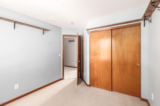 217 Knight Dream St, Delaware, OH 43015 - unfurnished bedroom featuring light colored carpet, a closet, and a textured ceiling