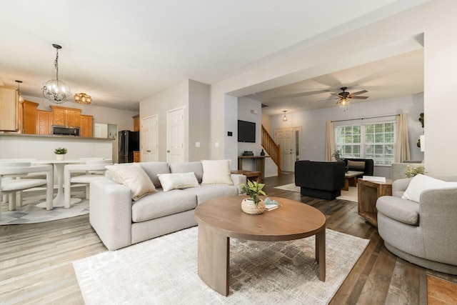 978 Vanwert Loop, Blacklick, OH 43004 - living area with stairs, light wood finished floors, a chandelier, and a ceiling fan