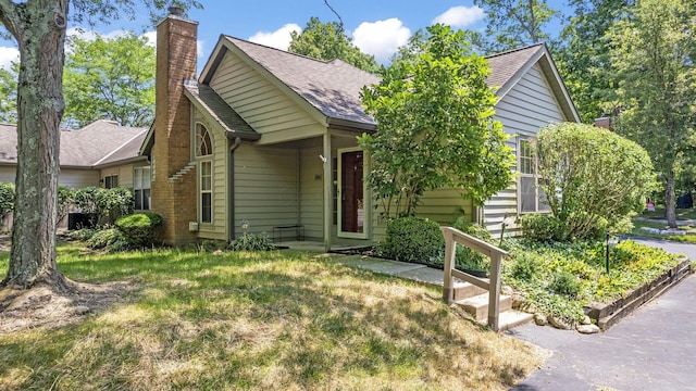 354 Hidden Ravines Dr, Powell, OH 43065 - view of front of house with a chimney, a shingled roof, and a front lawn