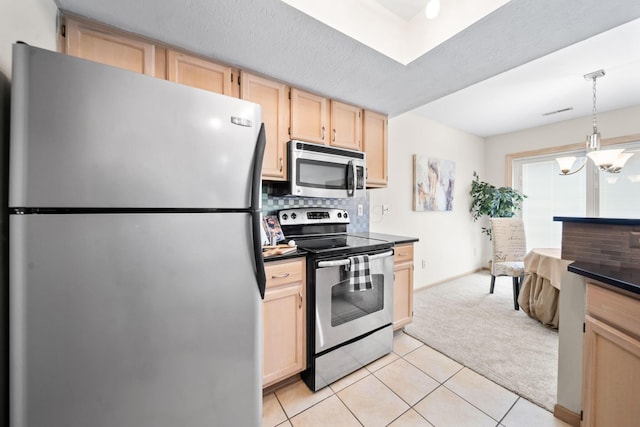 354 Hidden Ravines Dr, Powell, OH 43065 - kitchen with stainless steel appliances, light brown cabinets, dark countertops, and light carpet