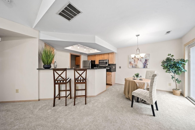 354 Hidden Ravines Dr, Powell, OH 43065 - kitchen featuring stainless steel microwave, freestanding refrigerator, a peninsula, dark countertops, and a chandelier