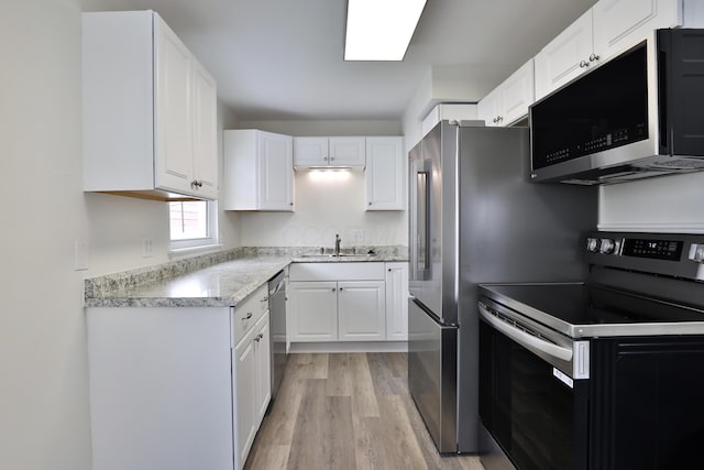 815 Eddystone Ave, Columbus, OH 43224 - kitchen with appliances with stainless steel finishes, light wood finished floors, and white cabinets