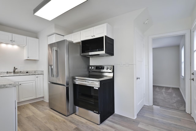 815 Eddystone Ave, Columbus, OH 43224 - kitchen with appliances with stainless steel finishes, light wood-type flooring, white cabinets, and light stone countertops