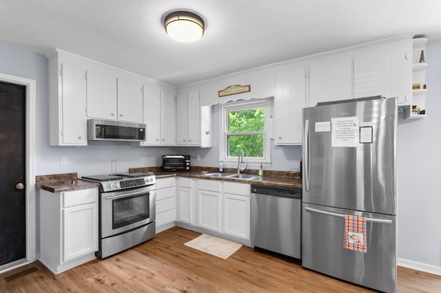 11962 Joppa Rd, Logan, OH 43138 - kitchen with stainless steel appliances, dark countertops, and white cabinetry