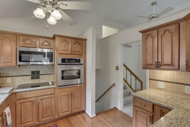 4861 Dickens Dr, Columbus, OH 43227 - kitchen with appliances with stainless steel finishes, a ceiling fan, light wood finished floors, light stone counters, and decorative backsplash