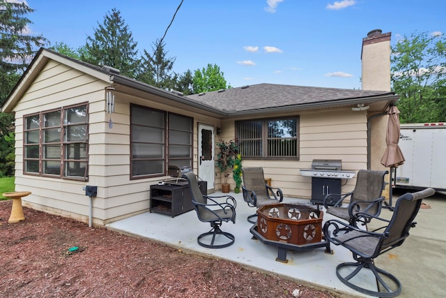 6983 Doran Dr, New Albany, OH 43054 - back of house featuring a chimney, a patio area, an outdoor fire pit, and roof with shingles