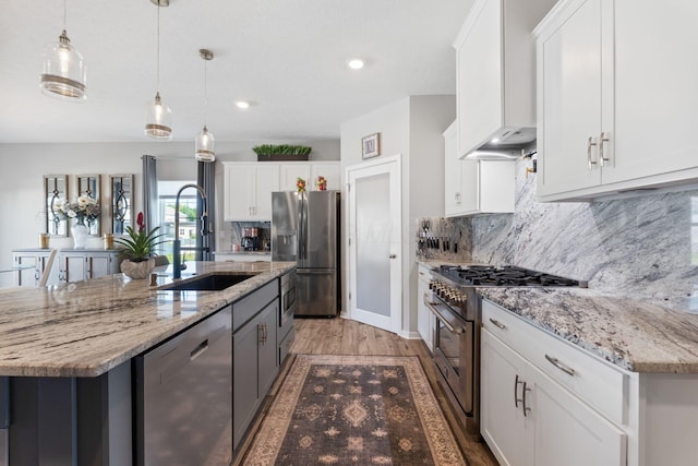 152 Natalie Ln, Granville, OH 43023 - kitchen with appliances with stainless steel finishes, light wood finished floors, an island with sink, backsplash, and recessed lighting