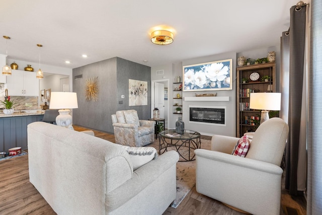 152 Natalie Ln, Granville, OH 43023 - living room with wood finished floors, a glass covered fireplace, and recessed lighting