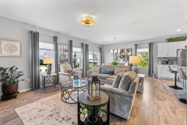 152 Natalie Ln, Granville, OH 43023 - living room with healthy amount of natural light, light wood finished floors, and a chandelier