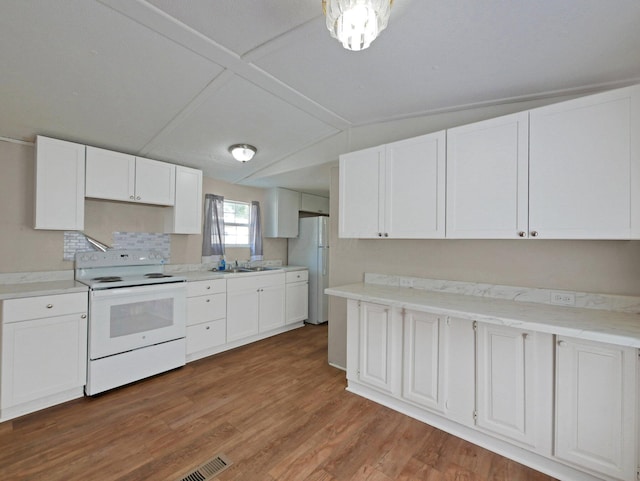 71 Biddle Blvd Unit 24, Bloomingburg, OH 43106 - kitchen featuring white appliances, lofted ceiling, white cabinetry, wood finished floors, and light countertops