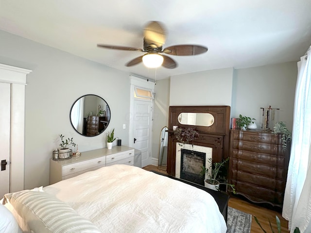 252 W Hubbard Ave, Columbus, OH 43215 - bedroom with wood finished floors, a ceiling fan, and a fireplace