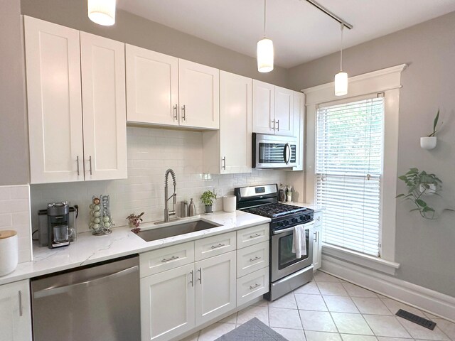 252 W Hubbard Ave, Columbus, OH 43215 - kitchen featuring appliances with stainless steel finishes, tasteful backsplash, light tile patterned floors, and white cabinets
