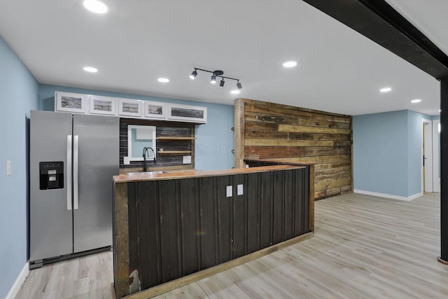 39703 Maysville Greendale Rd, Logan, OH 43138 - kitchen with stainless steel fridge with ice dispenser, light wood-style flooring, wooden walls, recessed lighting, and a kitchen island
