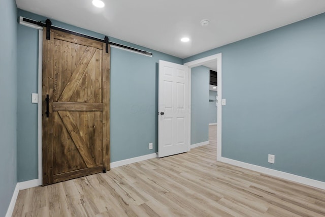 39703 Maysville Greendale Rd, Logan, OH 43138 - unfurnished bedroom with a barn door, wood finished floors, and recessed lighting