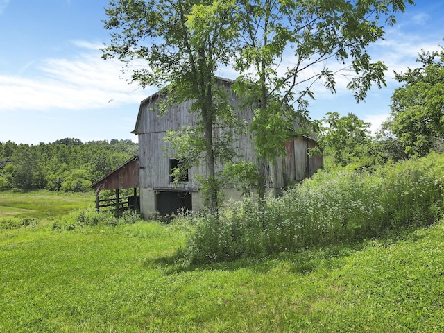 39703 Maysville Greendale Rd, Logan, OH 43138 - view of property exterior featuring a barn, an outdoor structure, and a wooded view