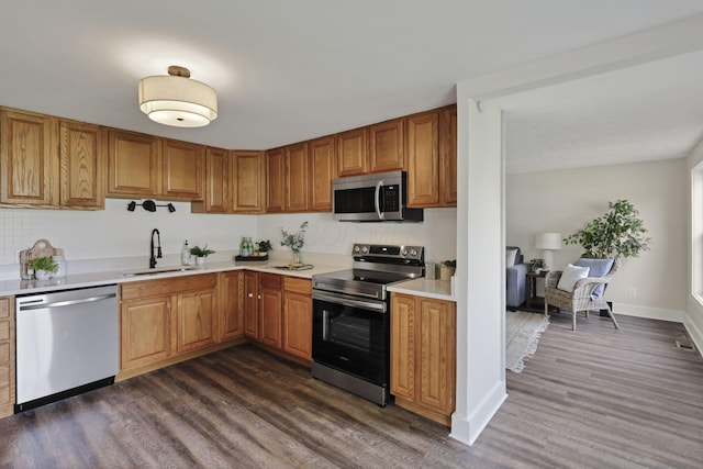 101 Circle Dr, Baltimore, OH 43105 - kitchen with stainless steel appliances, dark wood finished floors, light countertops, and brown cabinets
